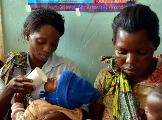 Zambian mothers feed their children ORS at a local clinic.