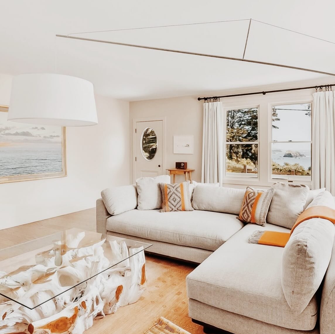 Incredible coastal views while lounging or working from this living room design in Mendocino. We wanted to bring elements from the outside landscape in with the driftwood coffee table, with handwoven alpaca pillows &amp; throw I sourced from artisans