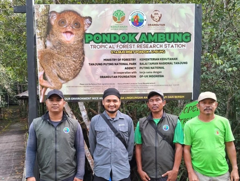 Staff stood in front of sign that reads 'Pondok Ambung Research Centre'