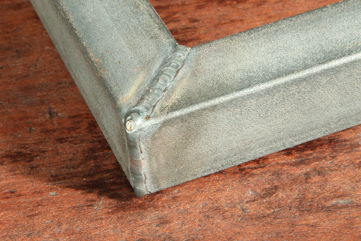 Exposed butt and fillet weld (flat surface and corner joint) for distinctive aesthetics. The frame features advanced degree of oxidation.