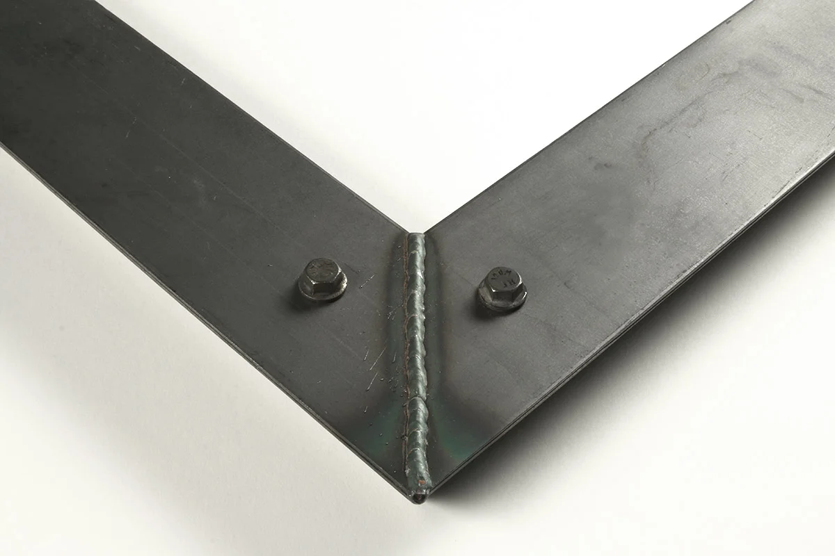 Detail of a 2.5” wide molding steel frame with bolt decoration