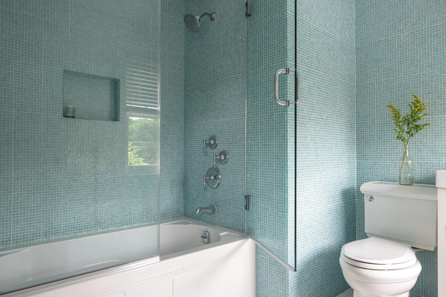 This tile evokes the beauty of seaglass 💙💚 We loved it so much that we extended it from the shower to the walls!