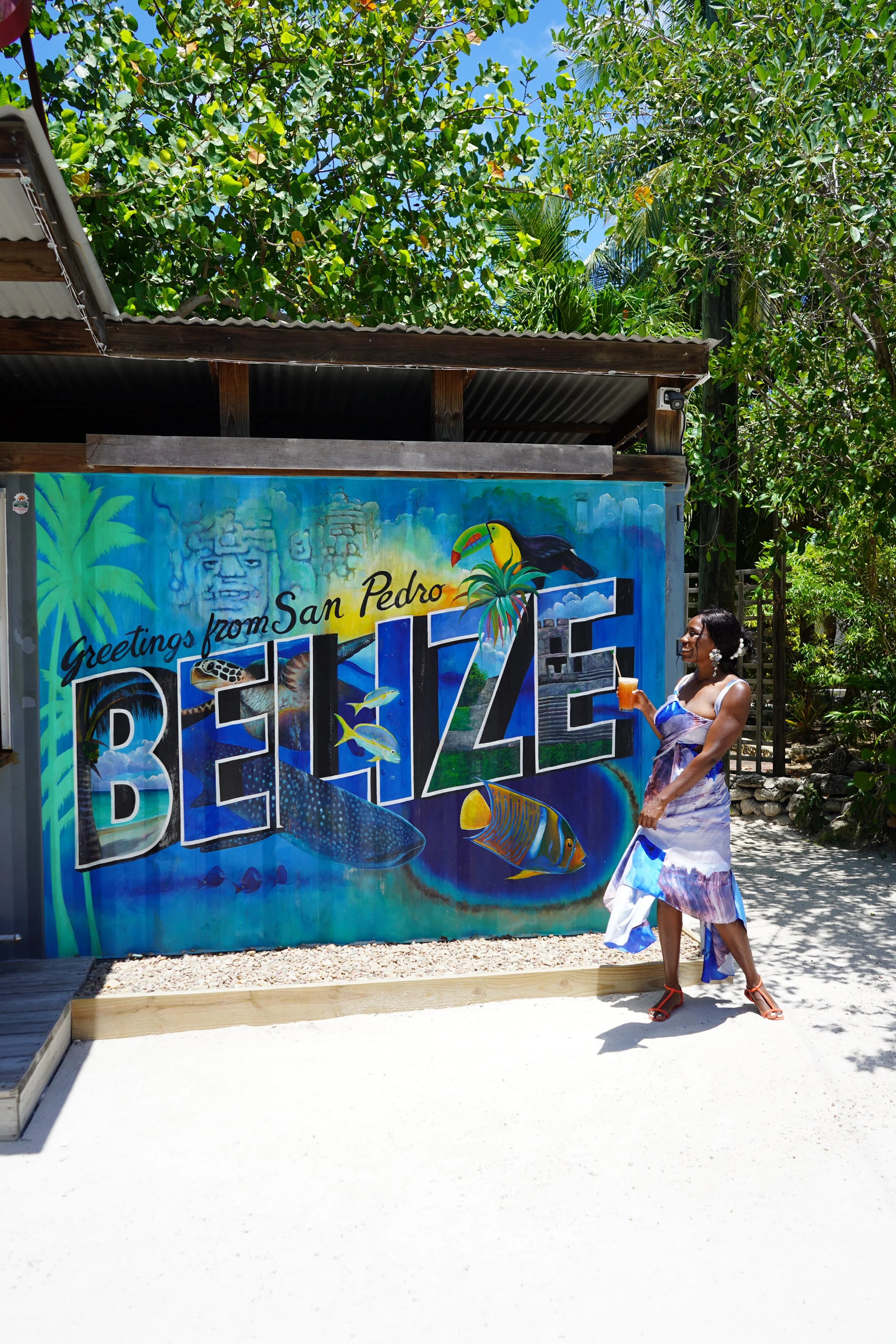 Christane position in front of A Belize sign at The Truck Stop in San Pedro Belize