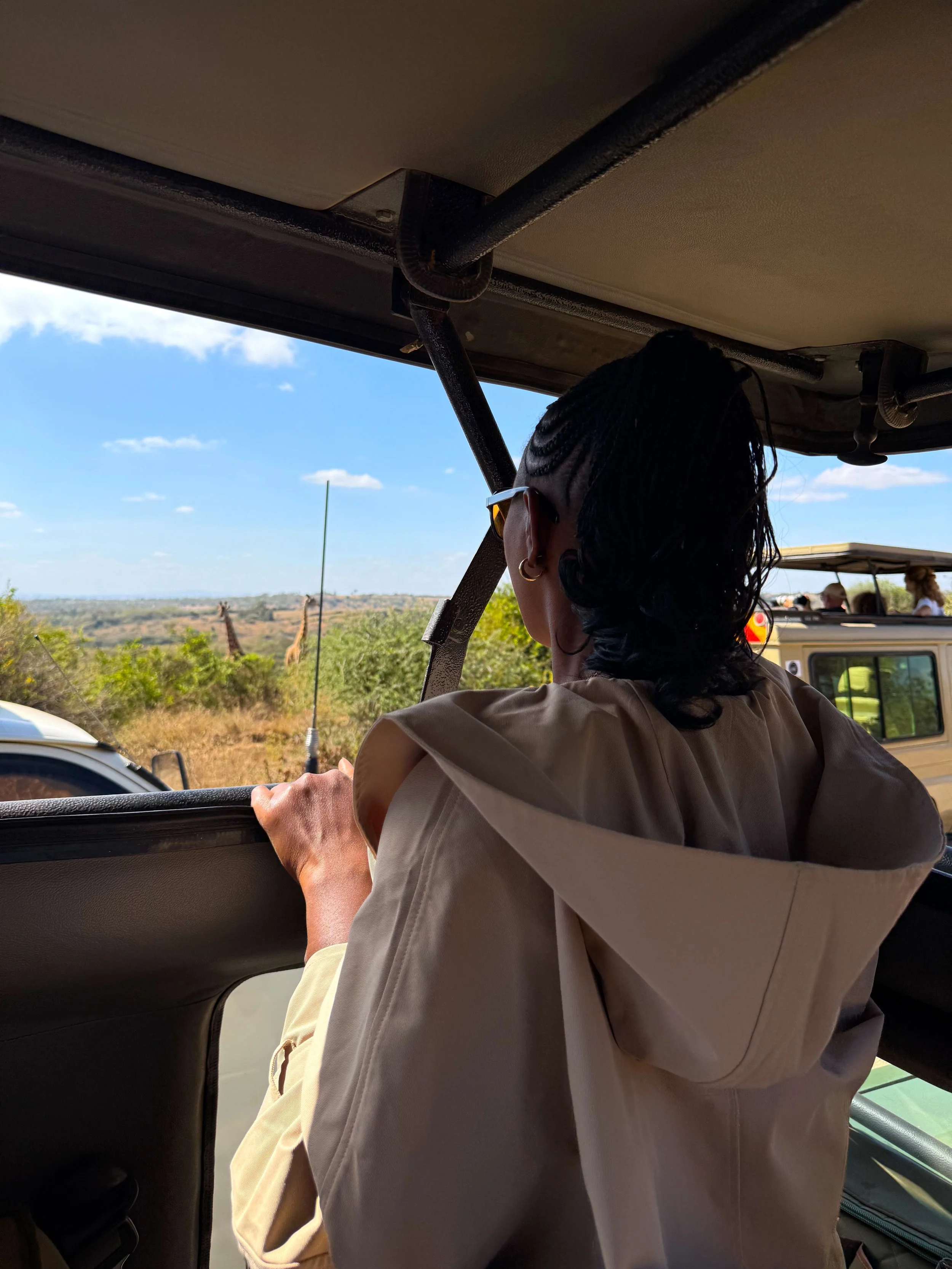 Kris in a 4x4 at Nairobi National Park Safari in Nairobi Kenya with a giraffe in the background