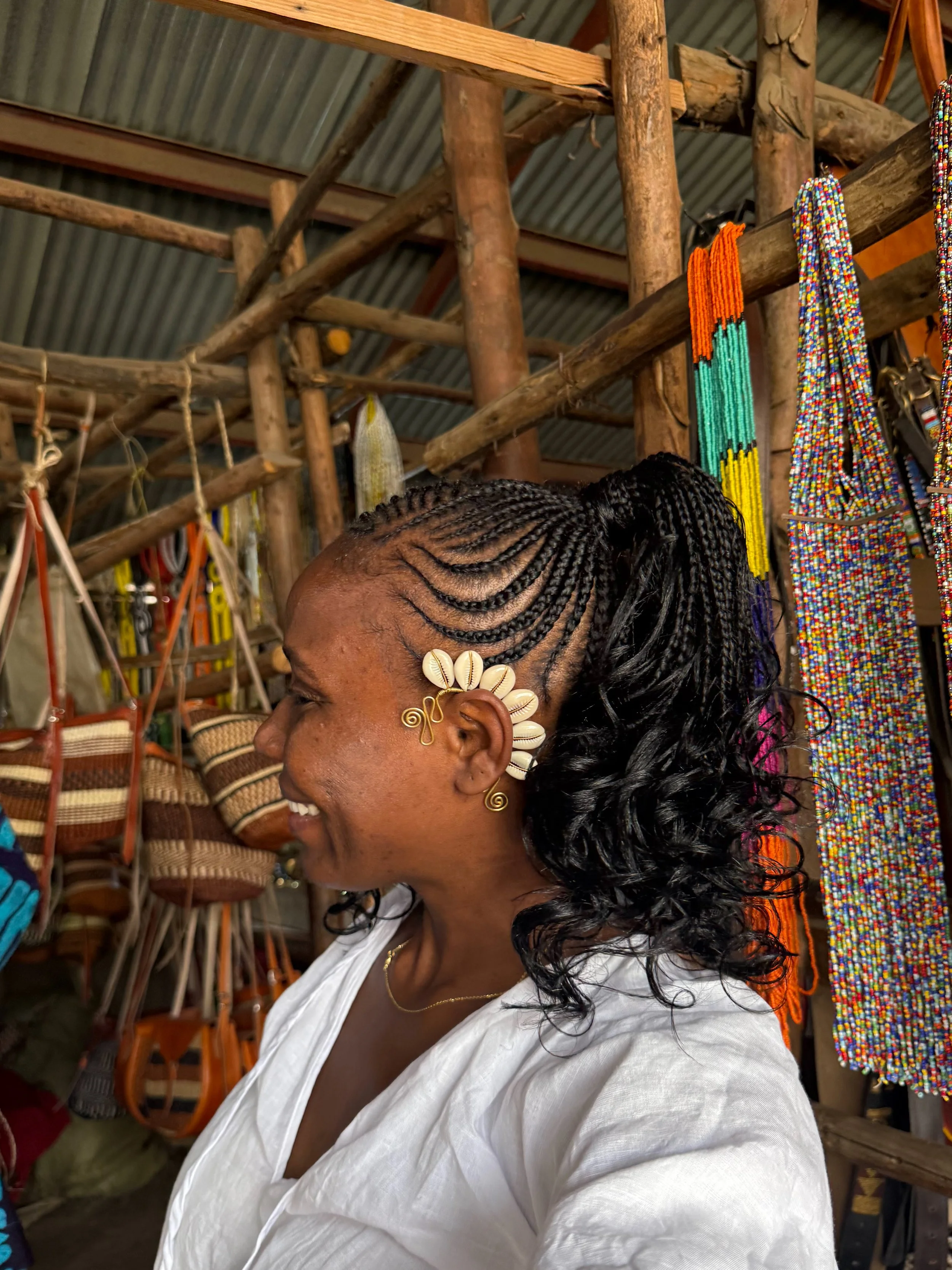A side profile of Kris with ear jewelry and cuff at the Kariokor Market in Nairobi, Kenya