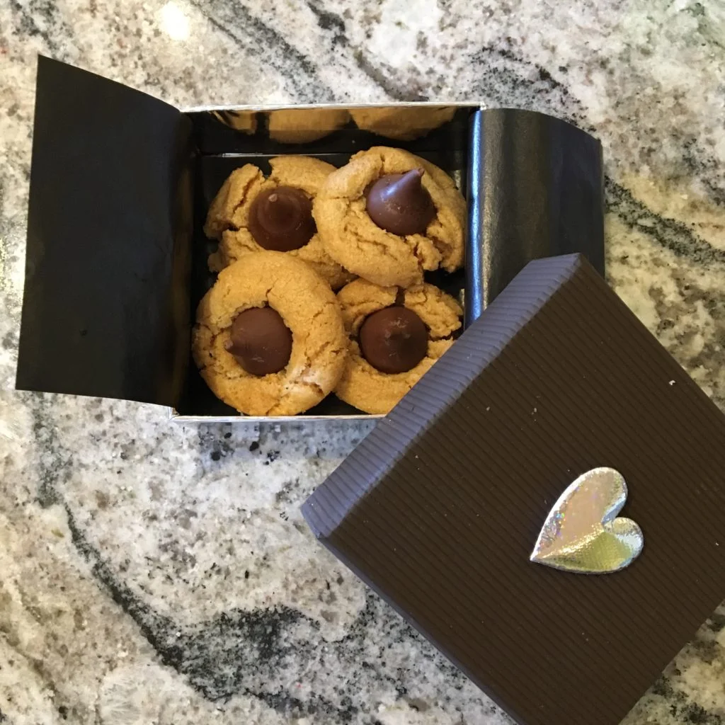 A box full of delicious cookies with Hershey's Kisses on top.