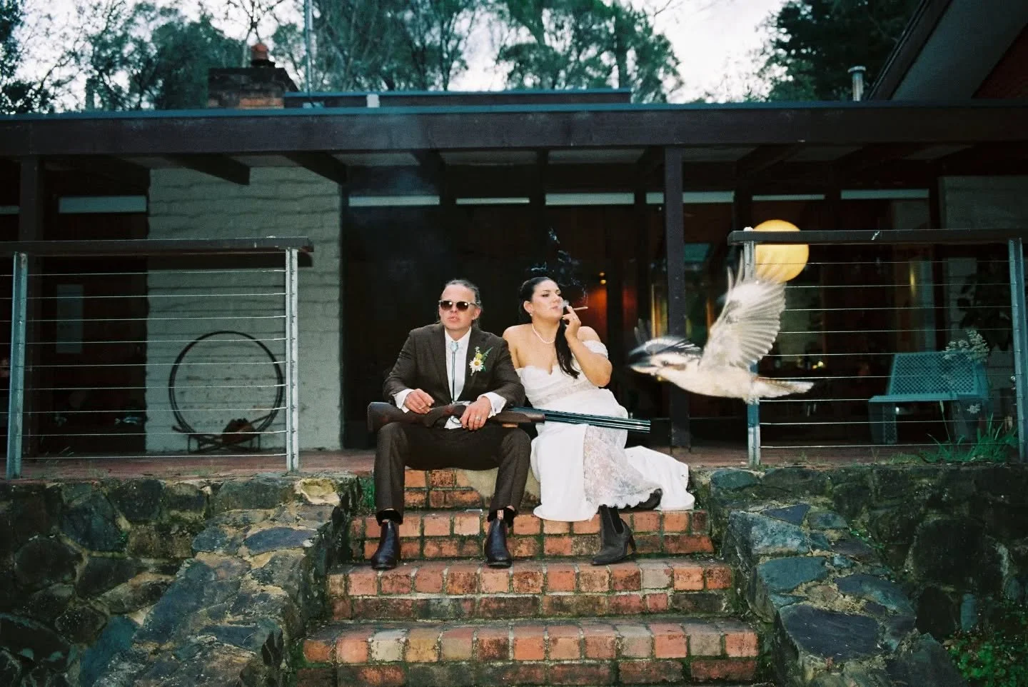 People will say it's A.I. 🤖 but it's shot on film. 🎞️

Nah it's just the most Aussie photo ever of my old mate Joey and his amazing wife Rach... Oh and this photo (dive) bombing kookaburra. 

The light was fading and dusk was setting in. We'd tried
