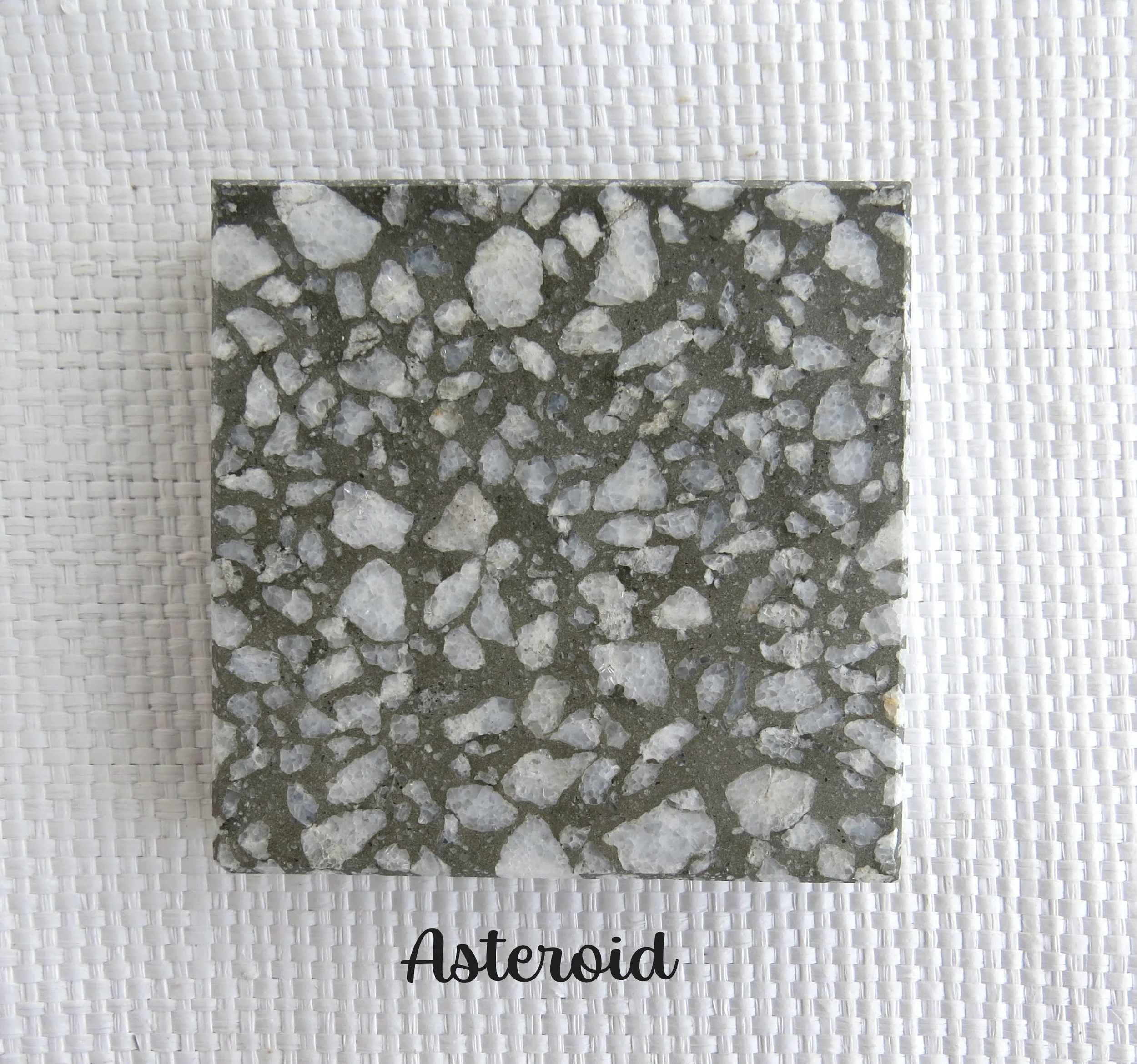 ASTEROID Tile- Flying through space at incredible speeds - a force of nature. NZ White Marble from the South Island in a dark gray base