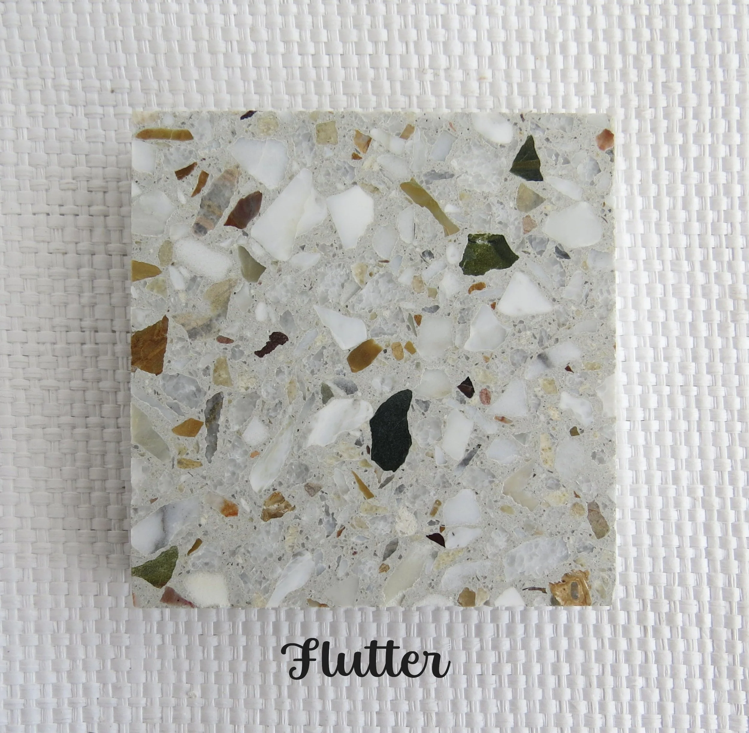 FLUTTER Tile- Butterflies fluttering through our gardens create so much delight, with their whimsical flight. A combination of recycled white marble, local  NZ stone and a touch of green from Aussie.