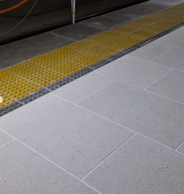 White Terrazzo tiles, gray and yellow tactiles and copings Aotea train station