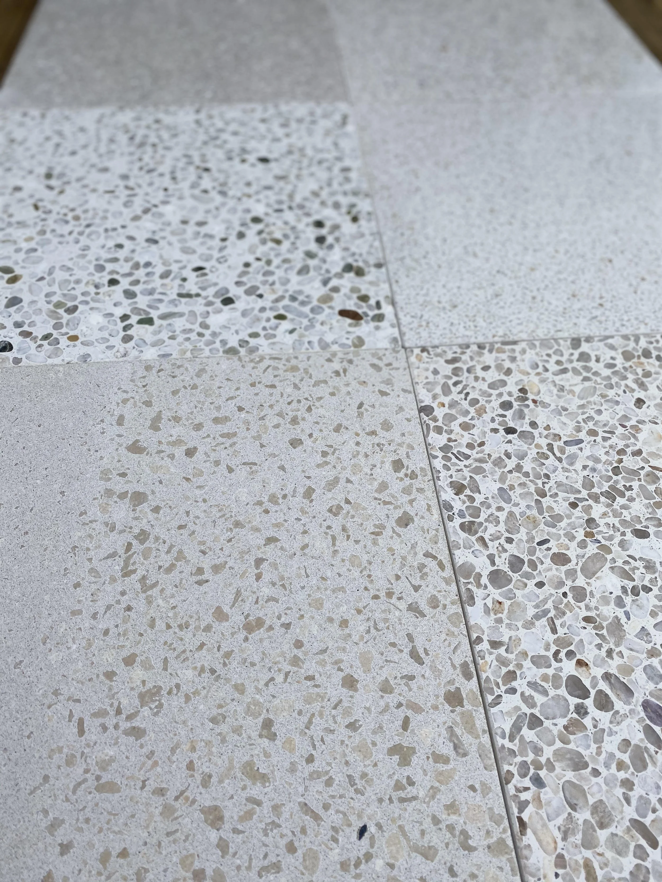 Close-up  Giacon Terrazzo white paver samples some having pebbles
