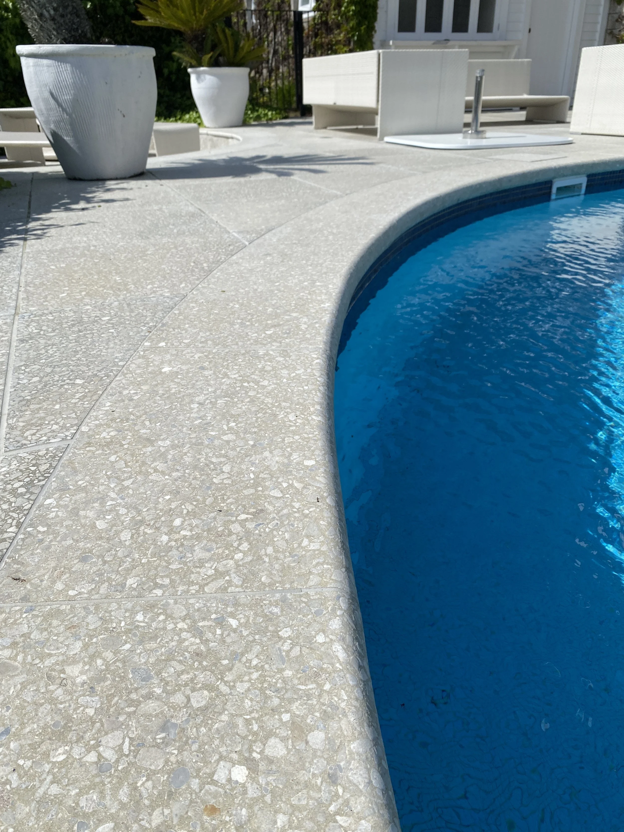 Close-up of a swimming pool with light gray terrazzo pavers and copings- Giacon Terrazzo NUANCE colour made for Clint Randell