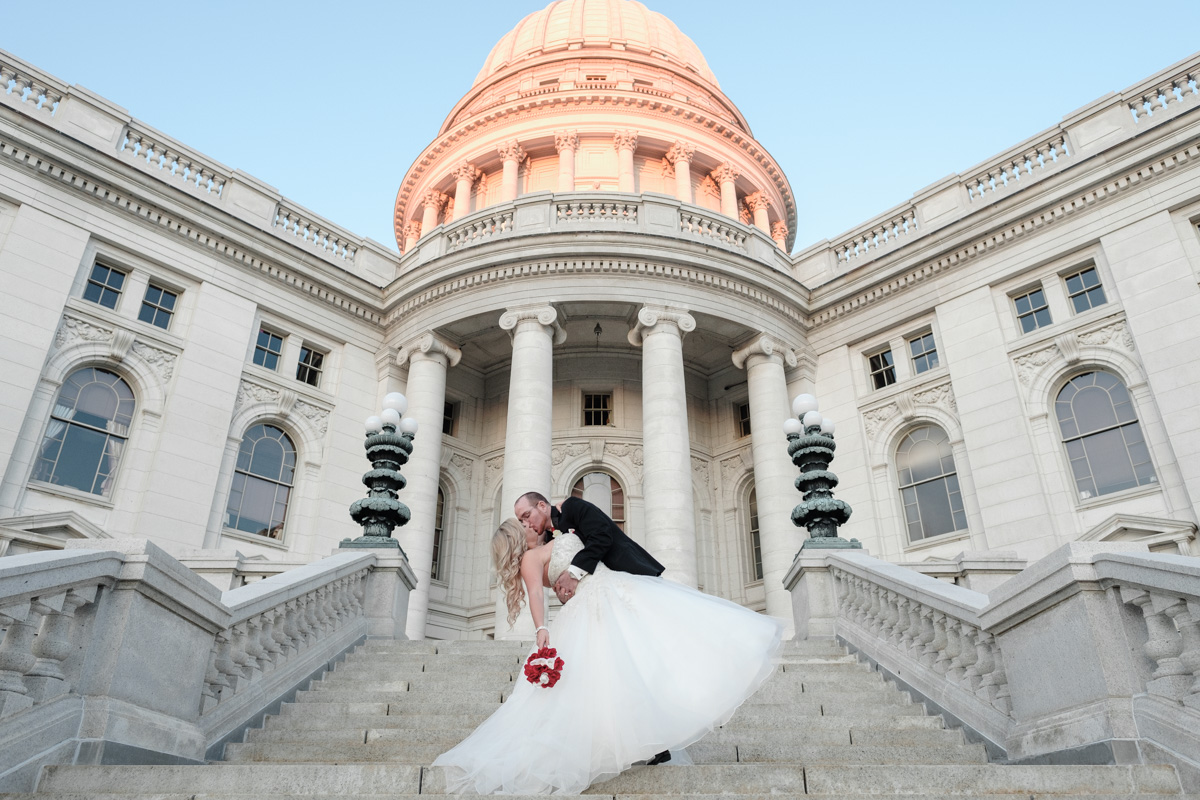 Groom dipping and kissing bride on the steps of the Capital Building in downtown Madison, Wisconsin.