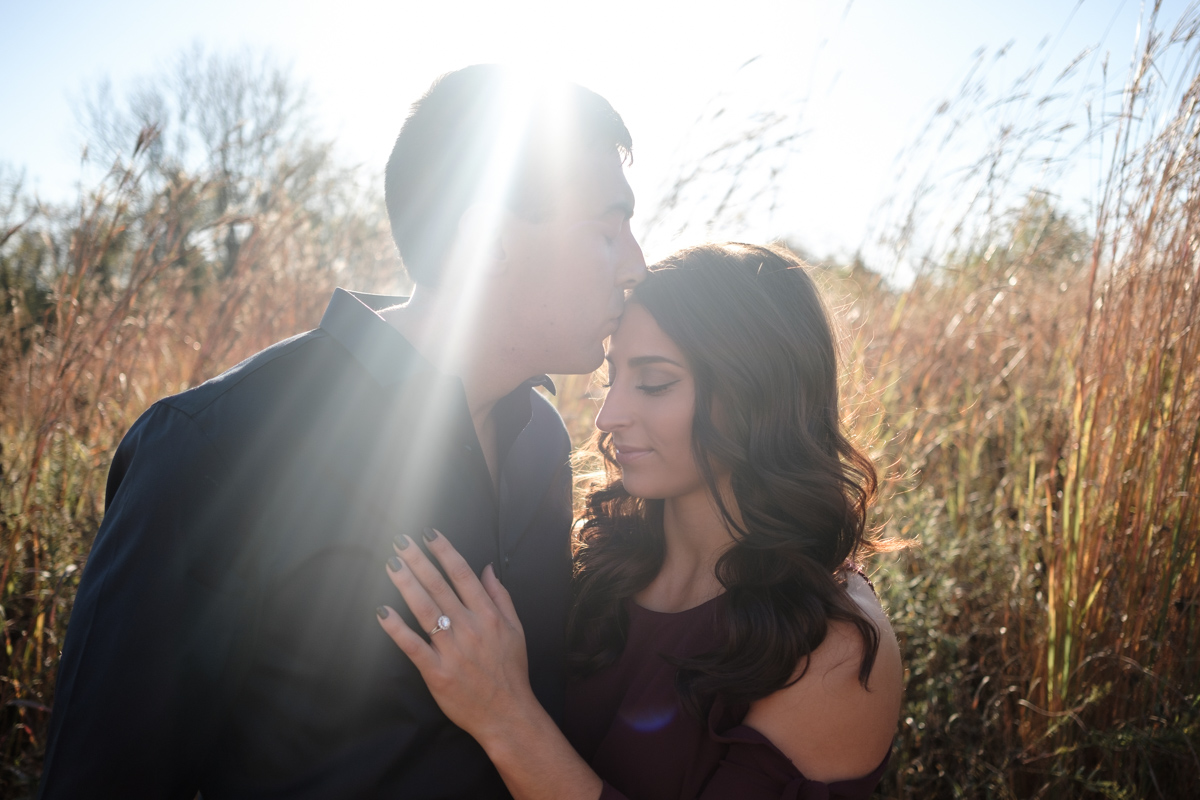Couple embraces with sunsetting behind them in Rock Cut State Park in Rockford Illinois