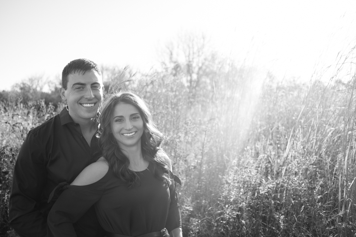 black and white photo of couple in tall grass in rock cut state park during their engagement session