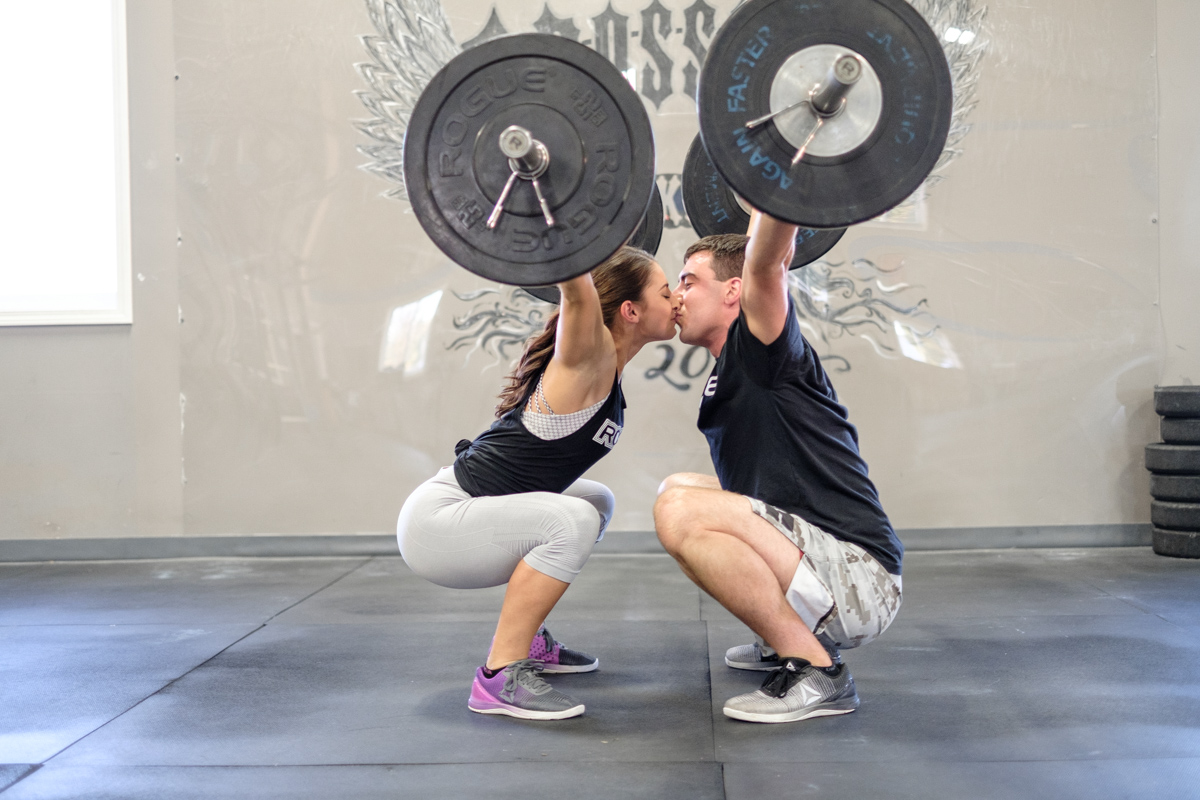 dual overhead press with couple kissing during lift at CrossFit Rockford