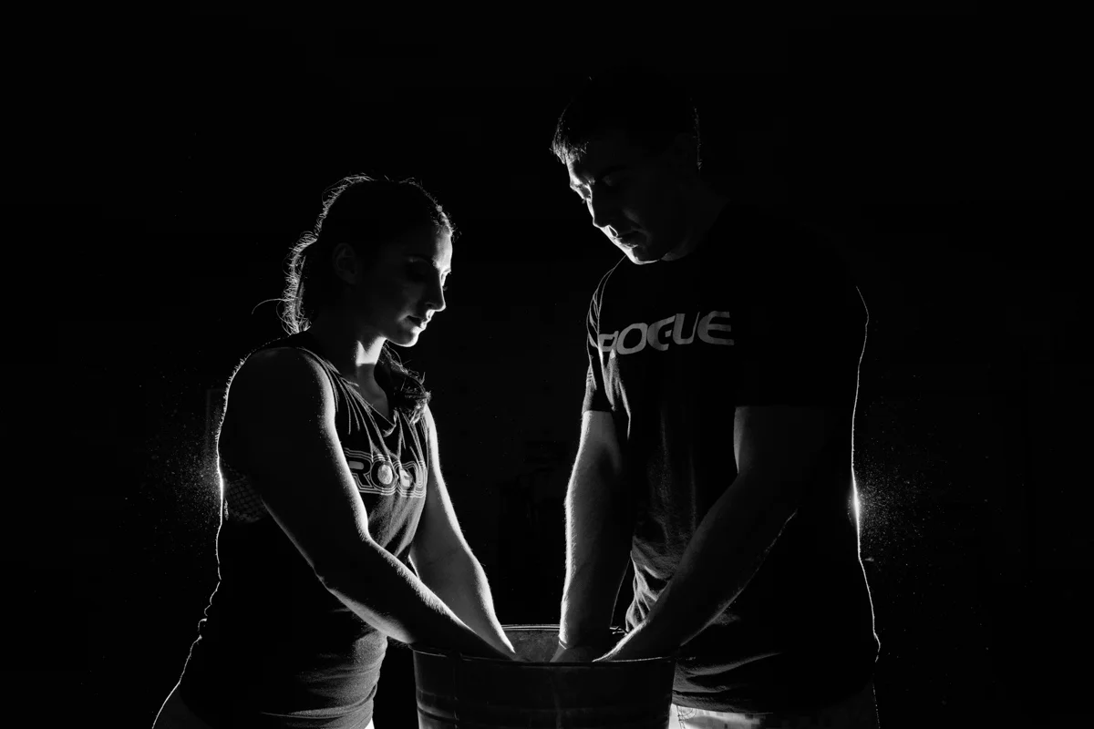 back lit photo of couple kissing and getting chalk for a lift at Crossfit Rockford
