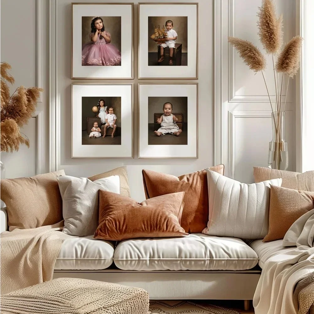 A living room with a white sofa adorned with multiple pillows in neutral and rust colors. On the wall above, four framed portrait photos of children are arranged in a 2x2 grid, depicting various children in different poses, with some holding objects 