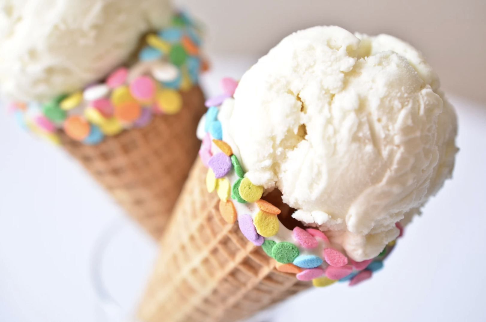 two waffle ice cream one with chocolate and vanilla  ice cream with sprinkles.
