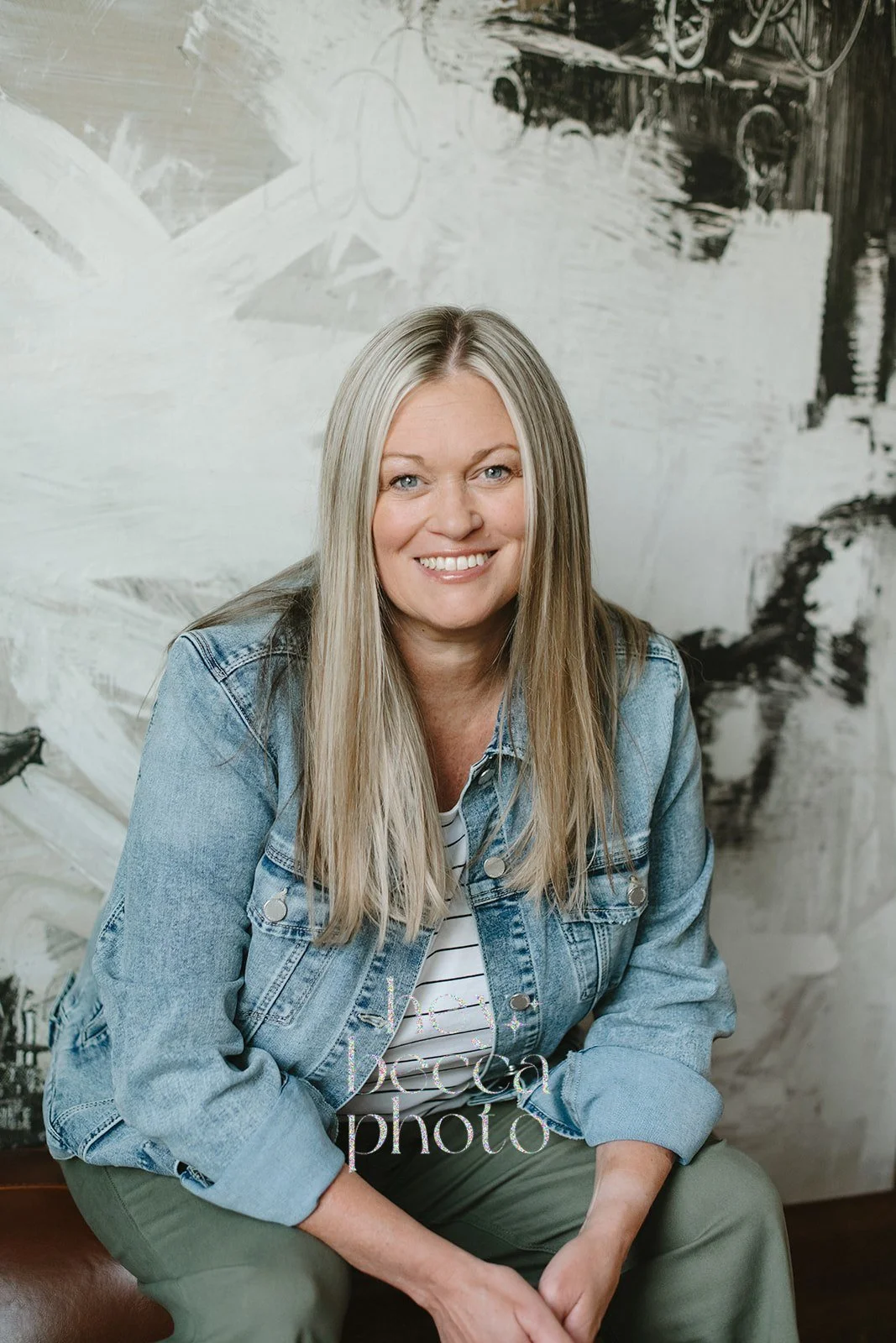Photo of Wendy Jensen, LCSW, Certified Eating Disorder Specialist, Founder of Inside Wellness, wearing olive green pants and a jean jacket with the sleeves partially rolled up, while smiling and looking into the camera