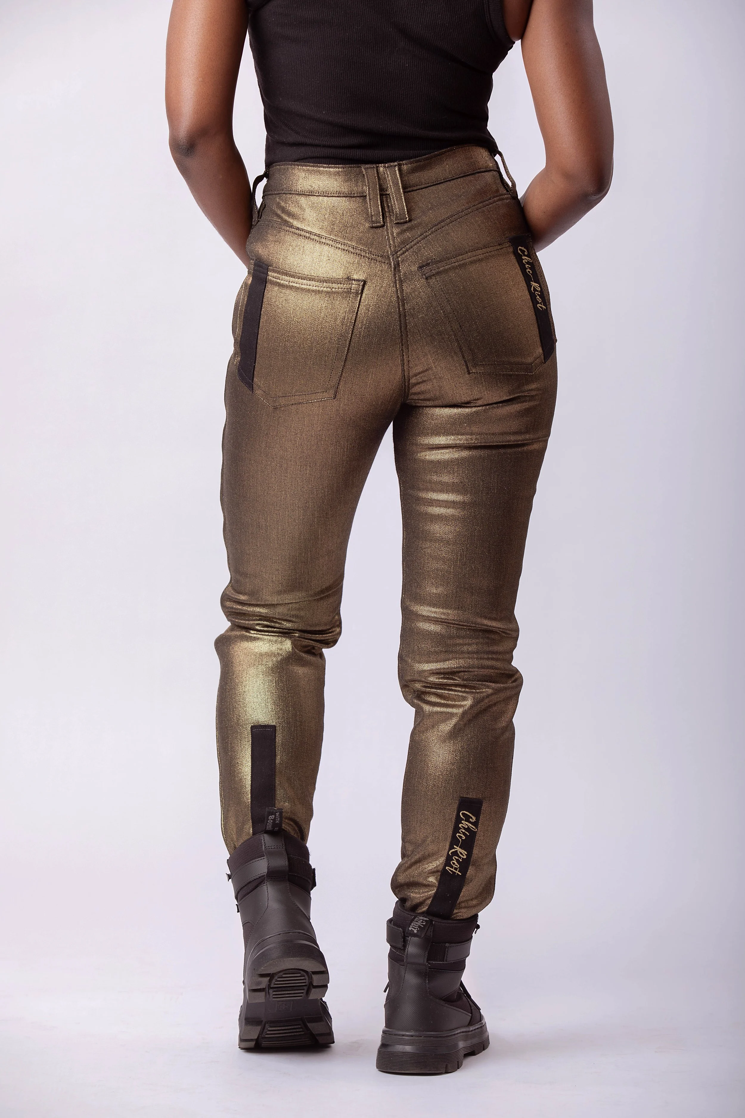 Back view of metallic gold moto pants with high waist, rear pockets, and tapered leg fit