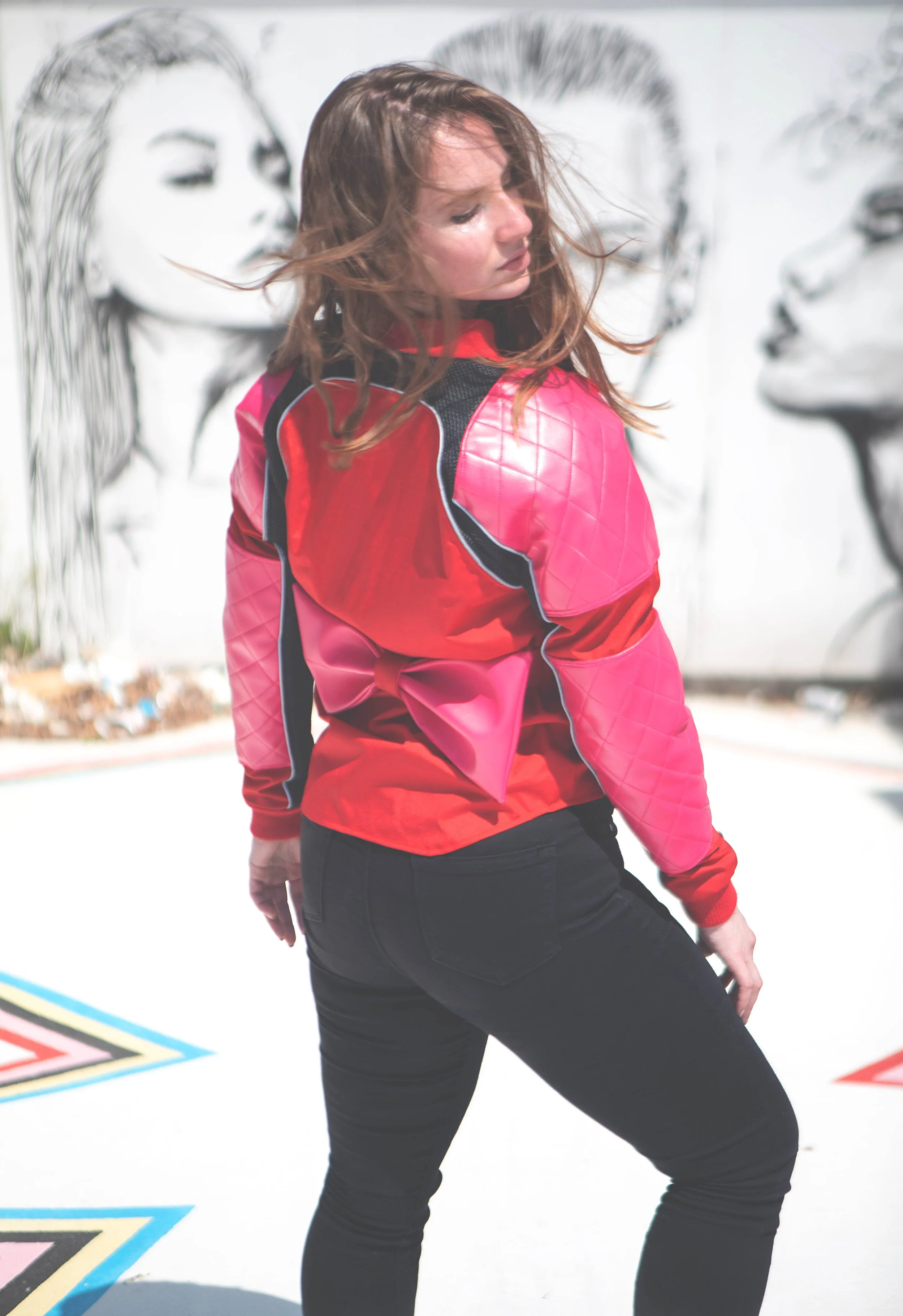 Women wearing a pink and red motorcycle jacket with a bow
