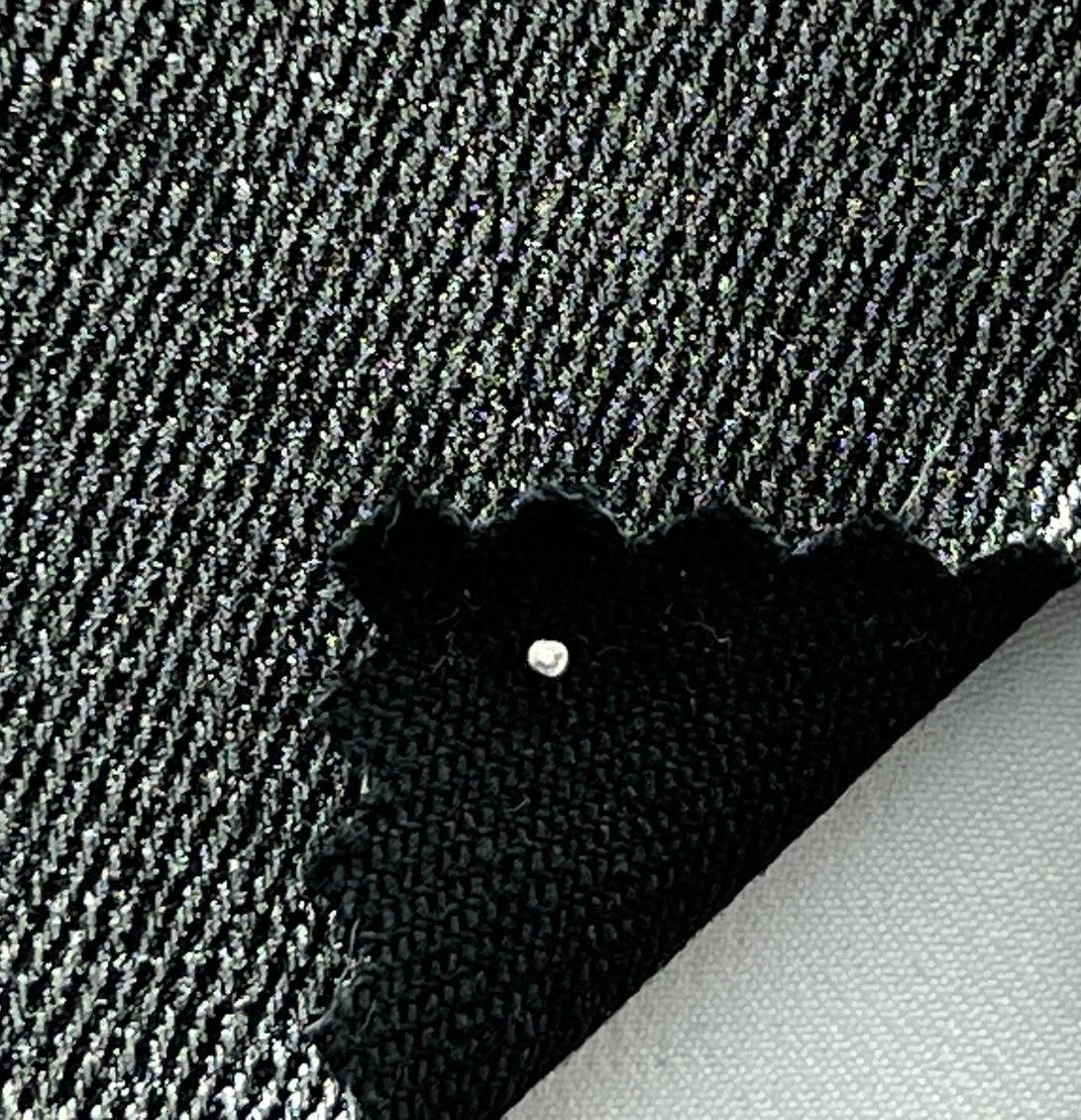 Close-up of moto pants fabric in gold black