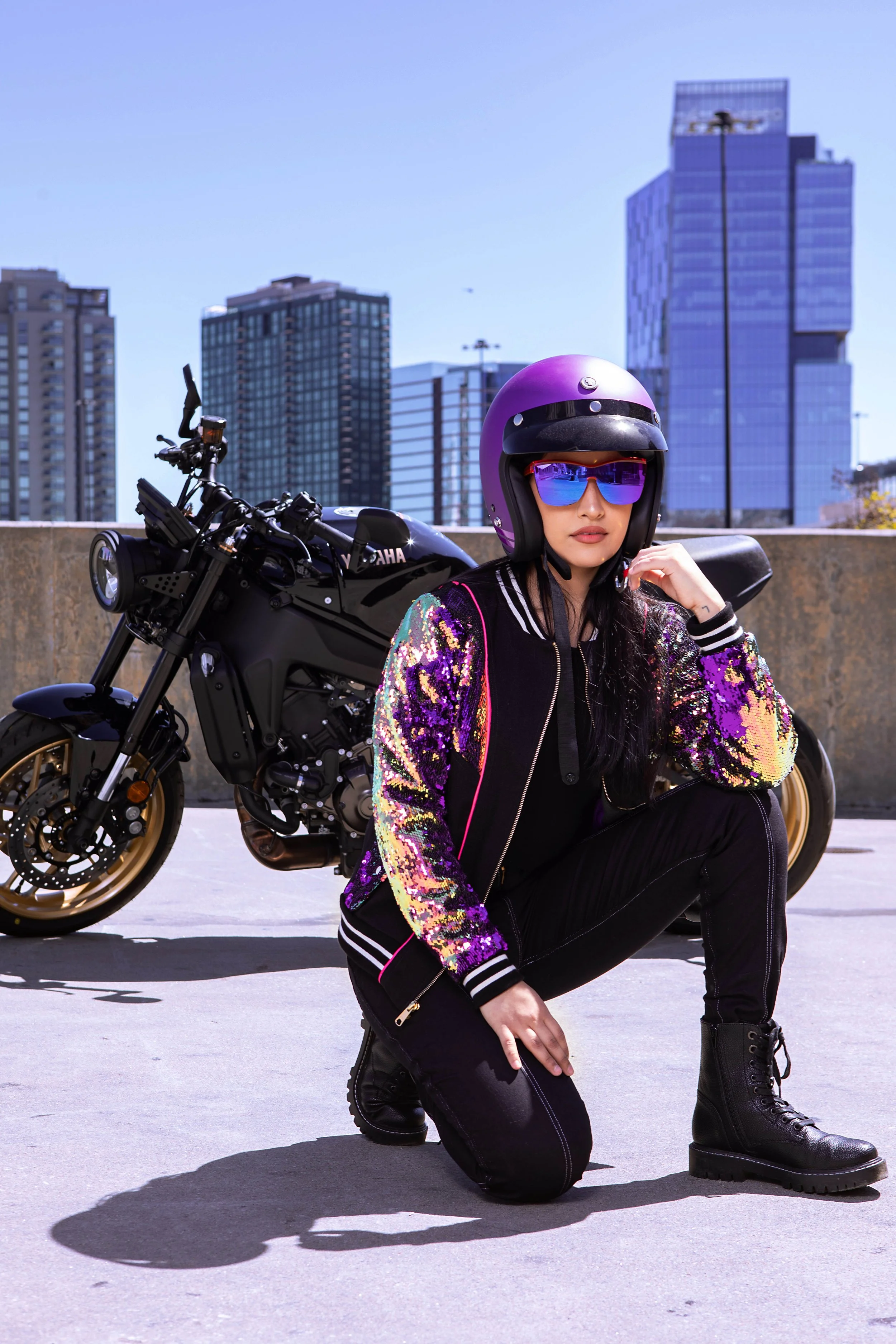 Women outside sitting in front of a motorcycle