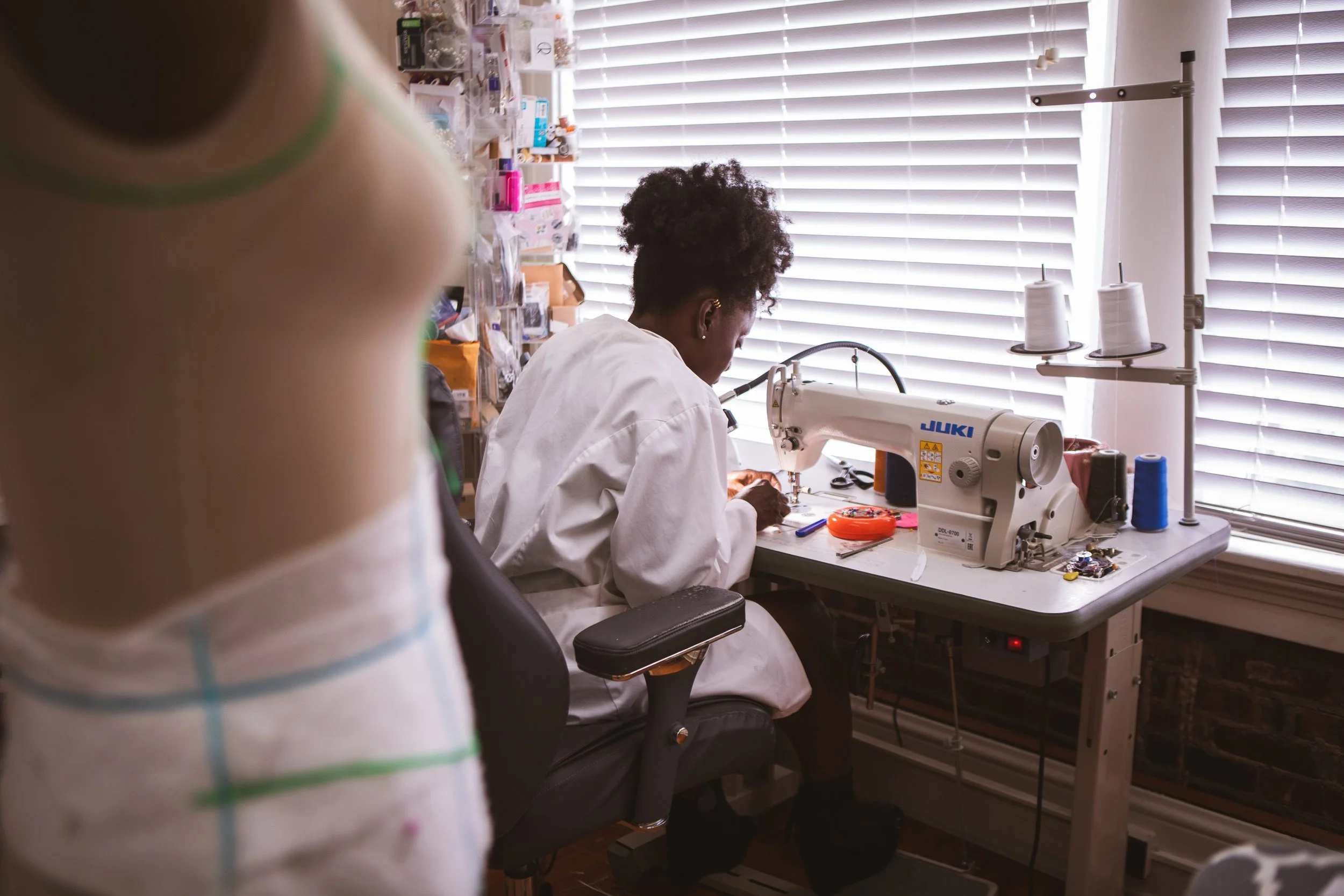 Woman sitting at a sewing table making a garment
