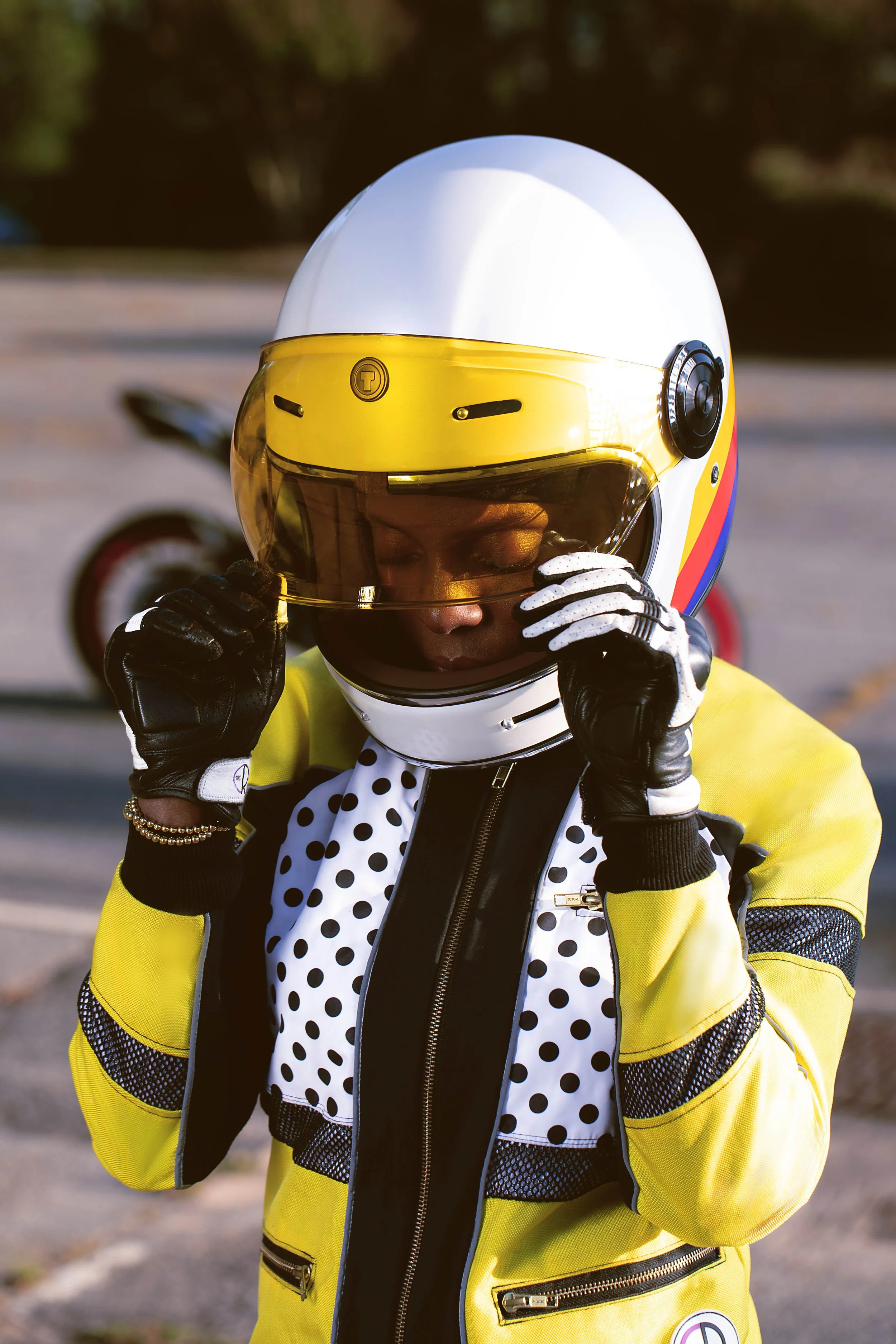 Women outside wearing a motorcycle helmet and bright yellow motorcycle jacket