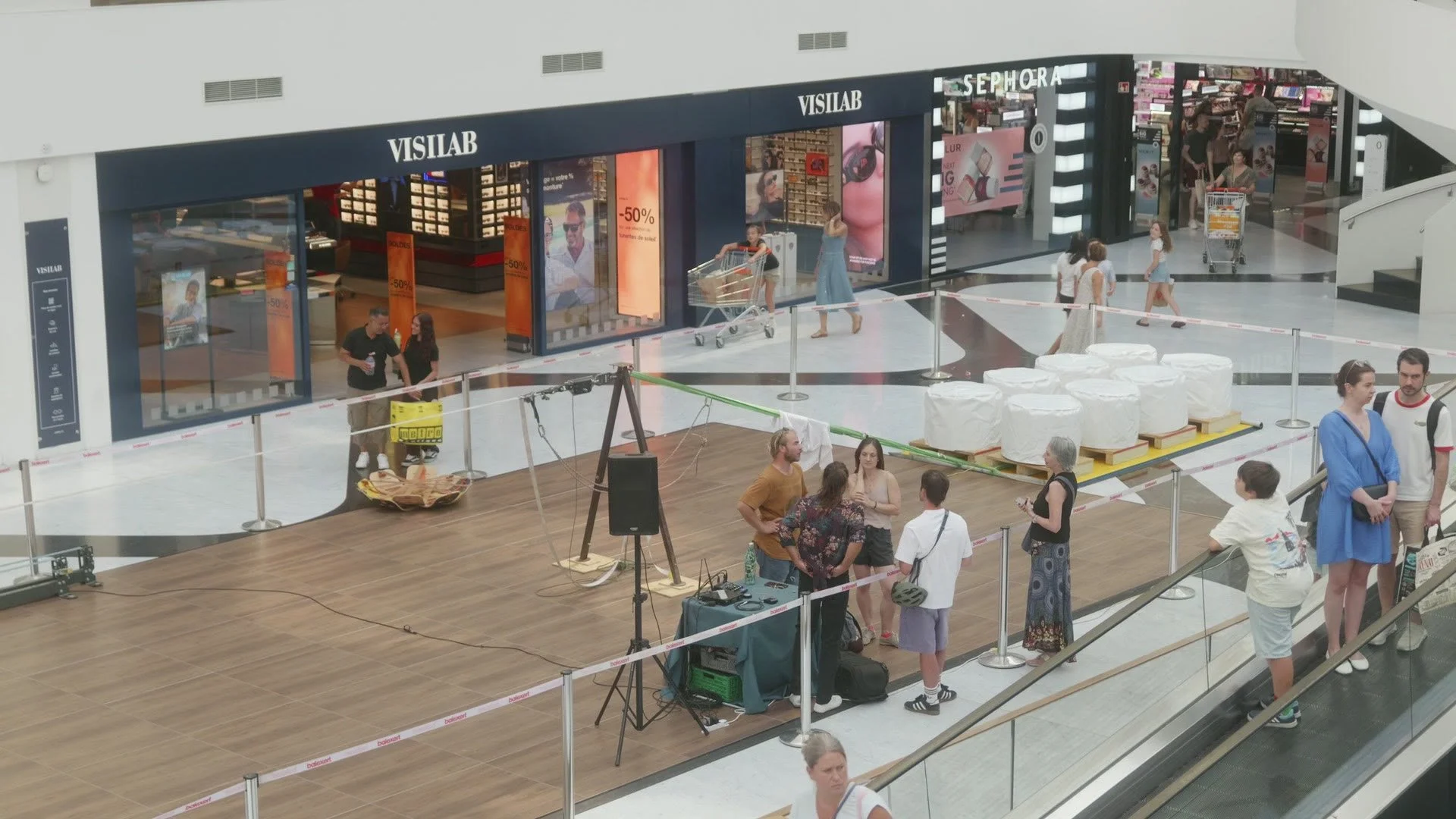Ancrage lesté en cylindres de béton habillés de caches blancs pour une slackline acrobatique au centre commercial Balexert