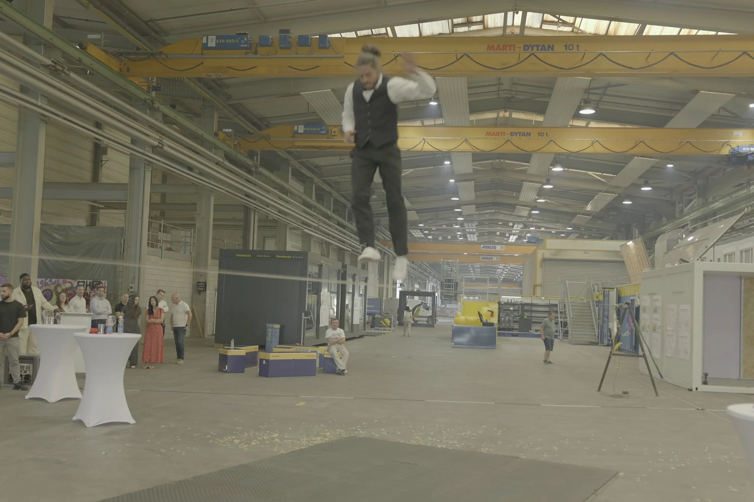 Show de slackline dans la halle de construction modulaire de Condecta à Wikon, entre modules et ponts roulants