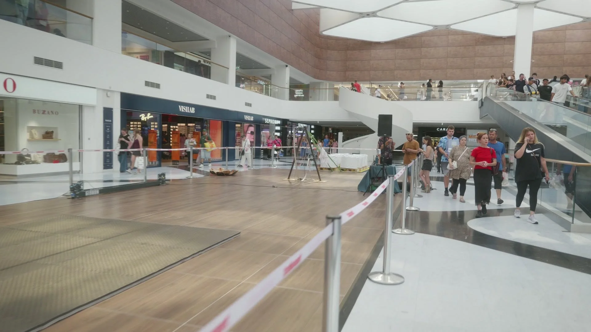 Grande Place du centre commercial Balexert à Genève : zone de show balisée entre le parquet et le sol en marbre