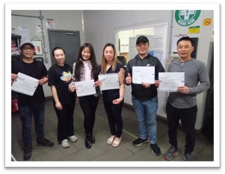 English students pose proudly with their certificates in the last class.