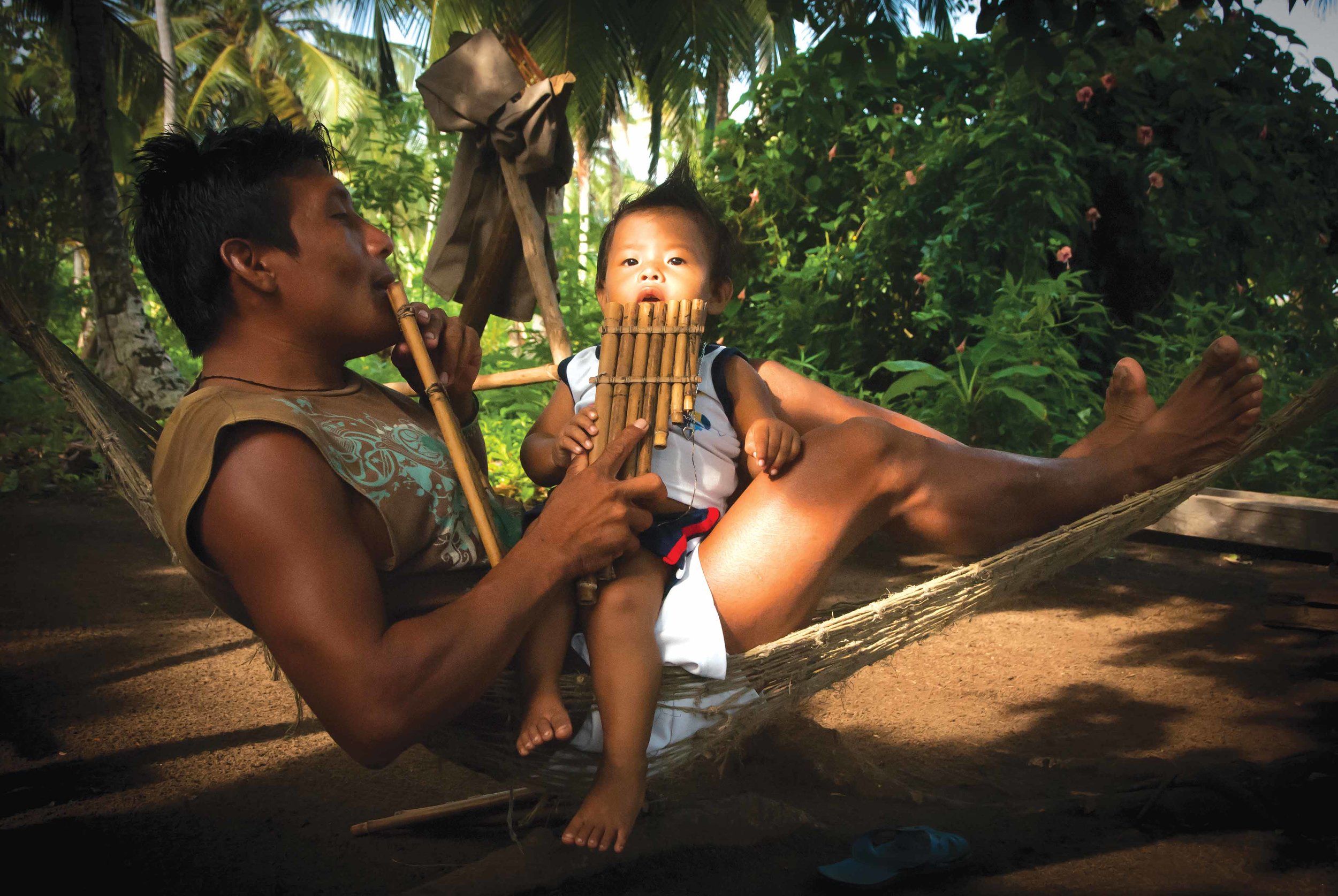 A member of the Campillo family musical group coaches the next generation in playing the kammu purwi, a Guna instrument fashioned from reeds. By producing and selling online the first album of Guna folkloric music, social entrepreneurs raised funds for sea turtle conservation while helping preserve the musical traditions of Panama’s Guna Indians. © Morrison B. Mast