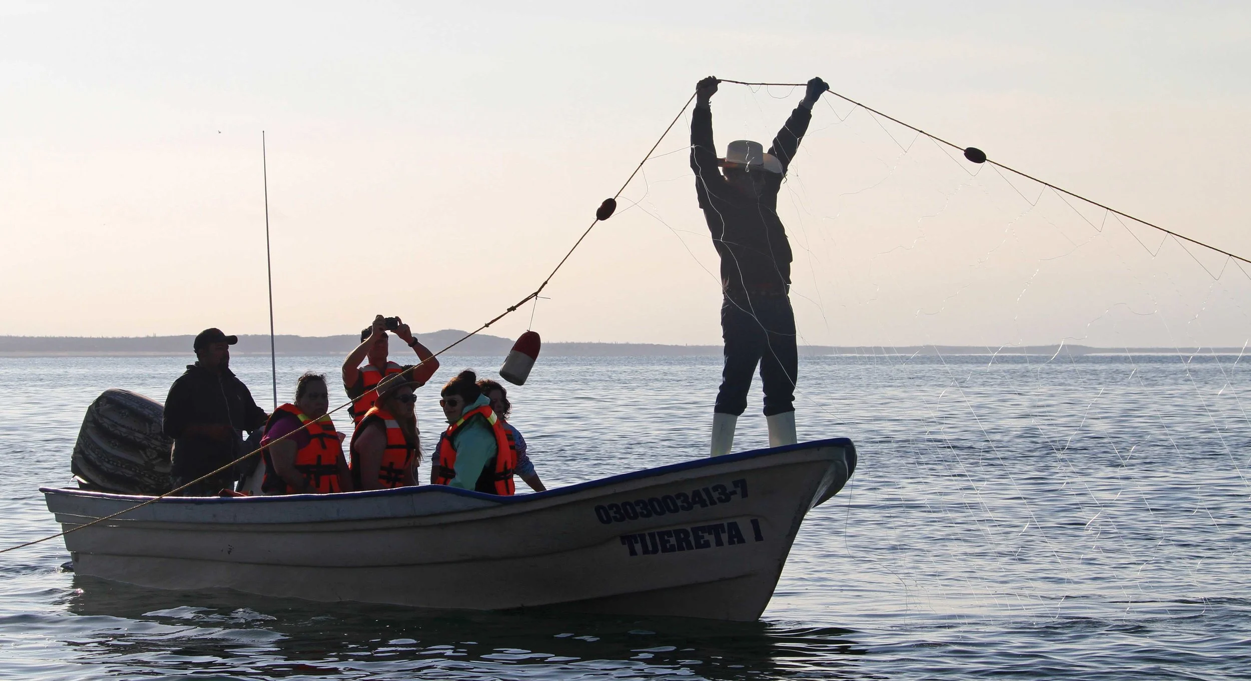Tourists watch in Baja California, Mexico, as a fisherman conducts in-water sea turtle monitoring. © Karen Delaney Wolverton