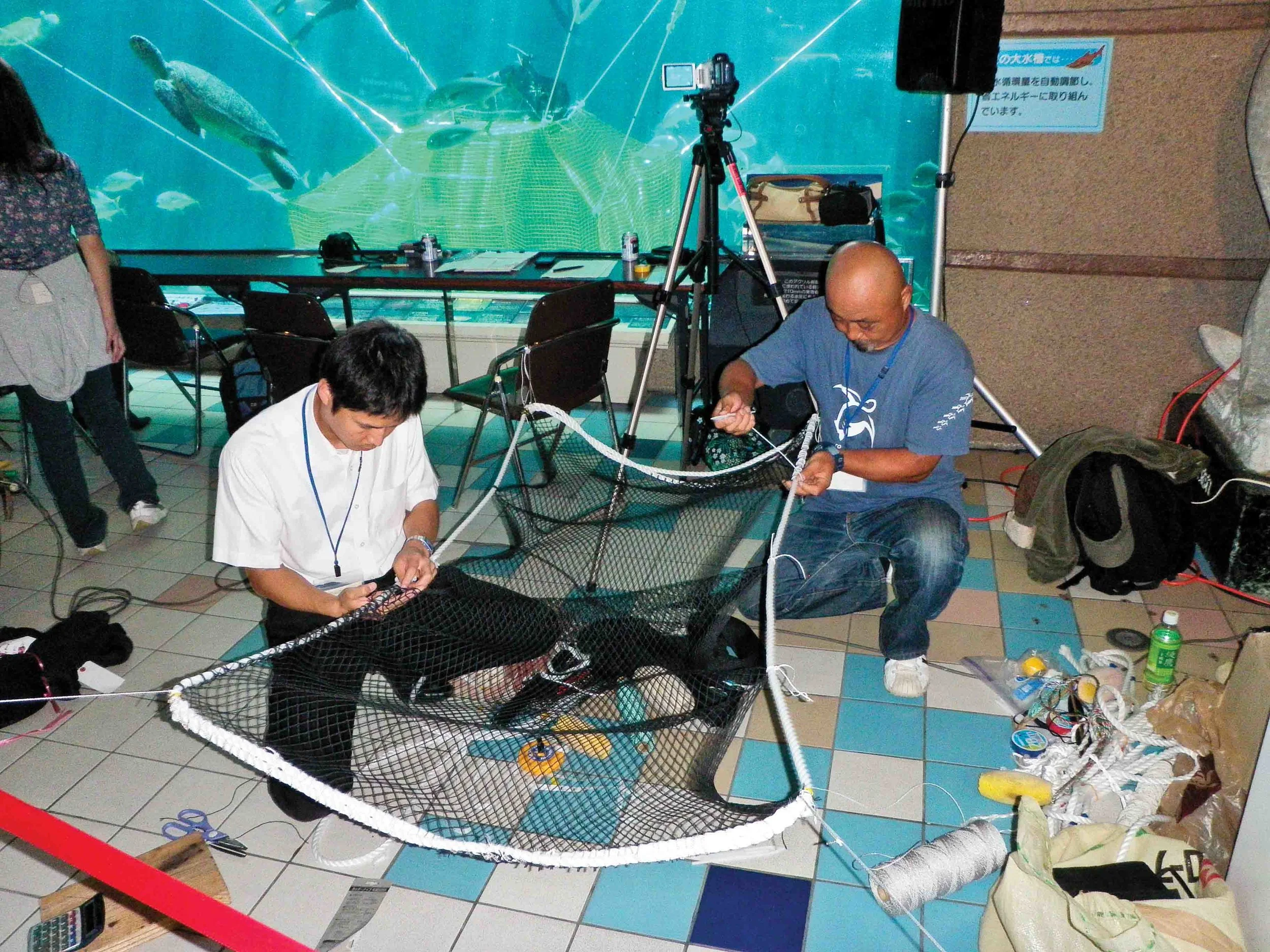 Workshop participants collaborate to modify the prototype for a pound net escape device (PED) as part of experimental trials in Kobe, Japan. © Sea Turtle Association of Japan