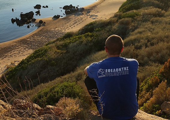 A volunteer for the sea turtle conservation organization Archelon looks out over a nesting beach in Greece © Kostas Papafitsoros