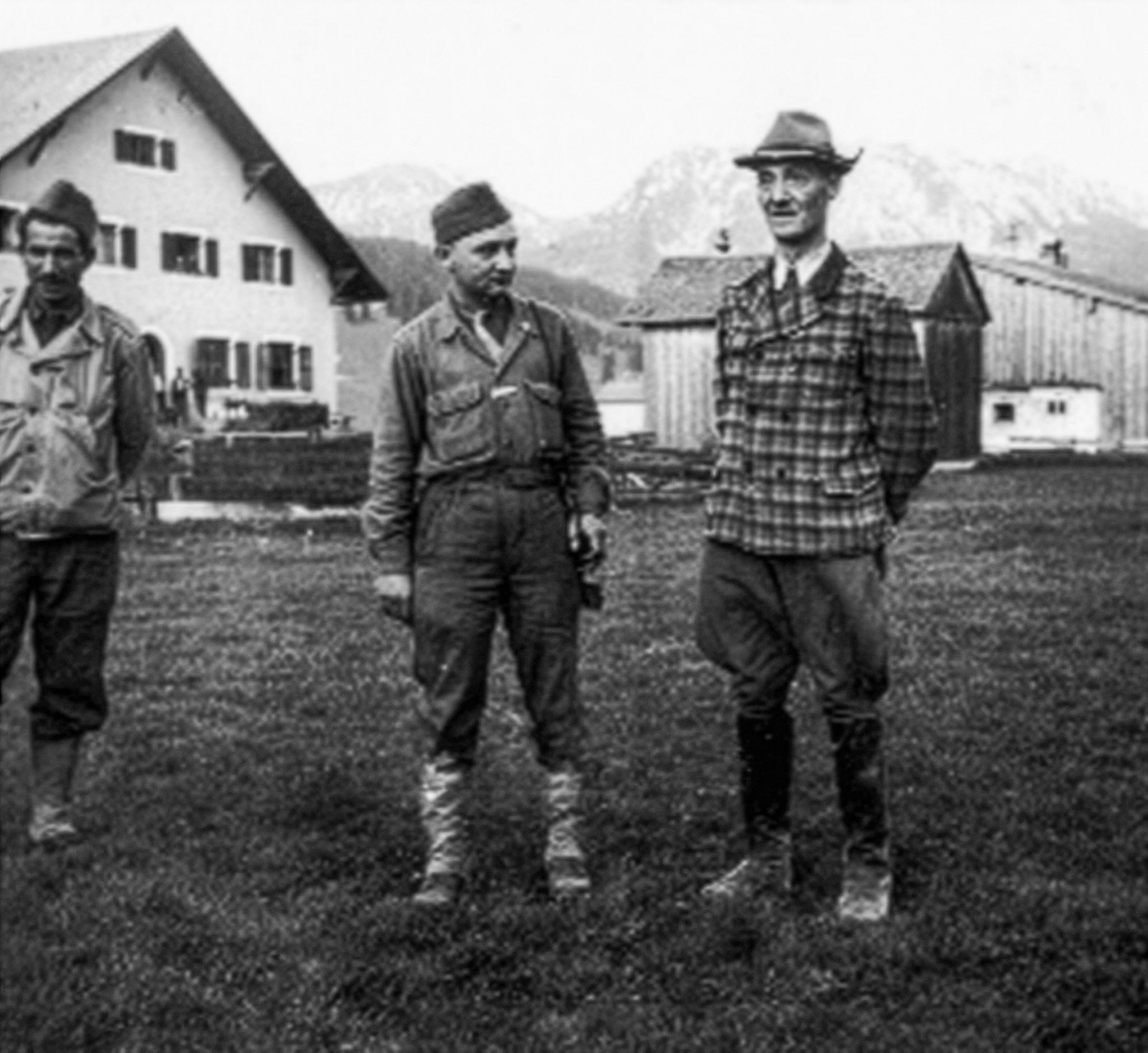 Oskar Dirlewanger standing outdoors in Austria in May 1945 shortly after his arrest by French forces, accompanied by armed guards in civilian and military clothing.