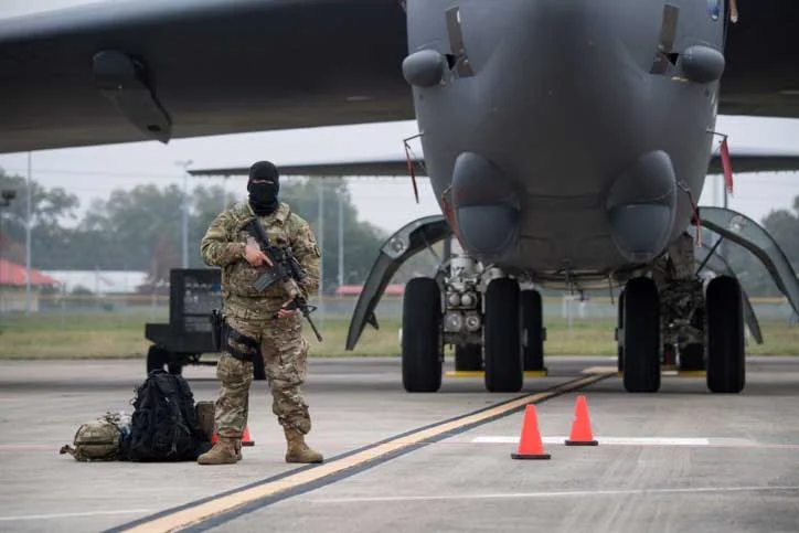Guarding nuclear weapons in flak jackets (body armor) while holding M16s with 240 rounds of ammunition each.