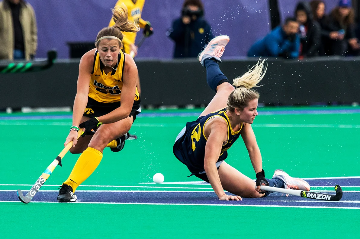 Iowa midfielder Sophie Sunderland tries to control the ball as a Michigan player crashes to the turf during the Semifinals in the Big Ten Field Hockey Tournament at Lakeside Field in Evanston, IL on Friday, Nov. 2, 2018. The no. 8 ranked Hawkeyes defeated the no. 7 ranked Wolverines 2-1.