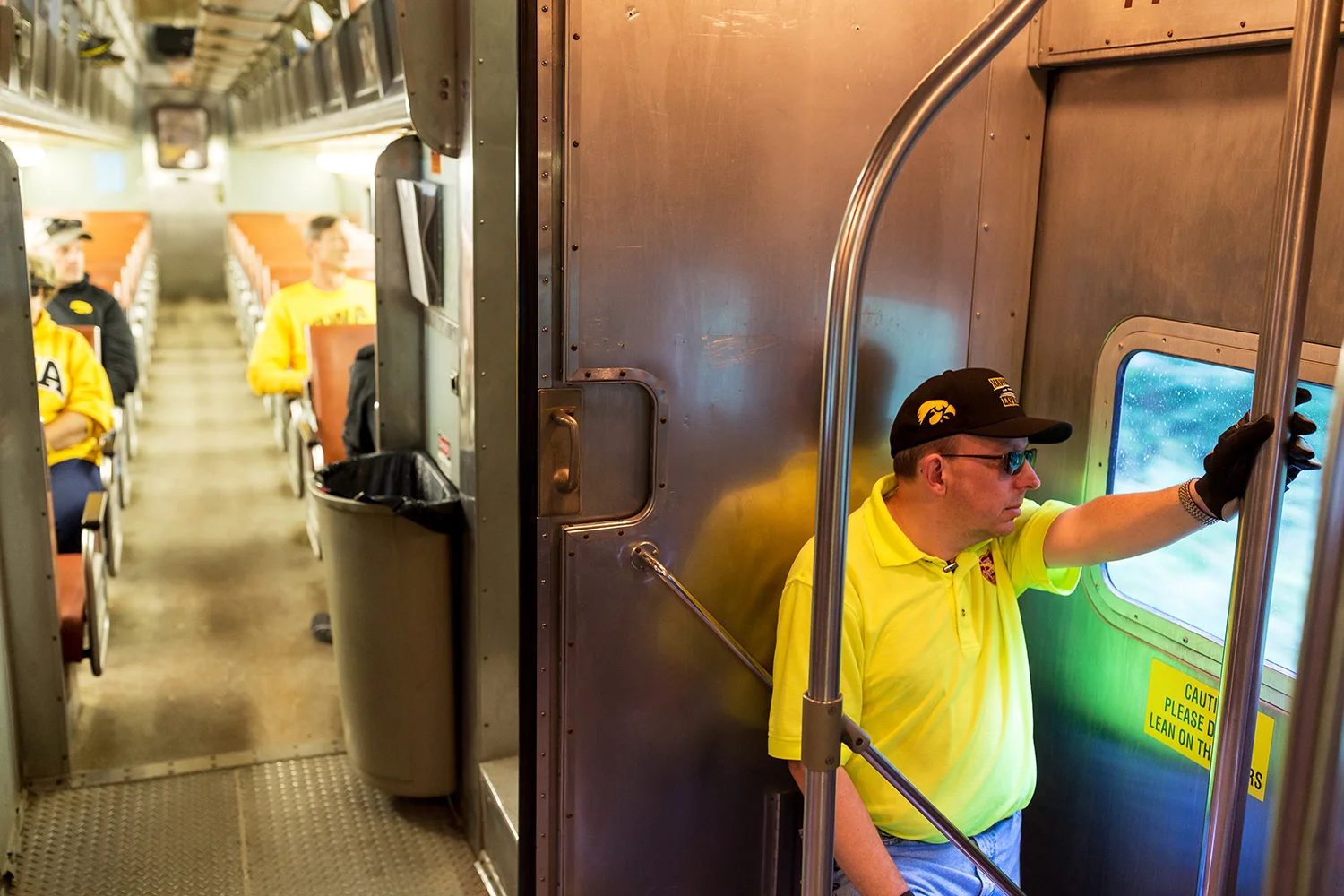 Volunteer car attendant Scott Evans watches the landscape roll by as fans ride the Hawkeye Express on Saturday, Sept. 22, 2018.