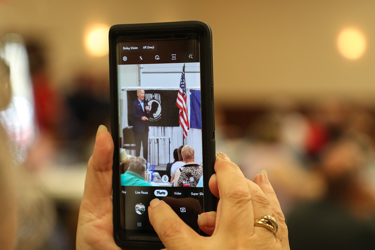  An attendee takes a photo of former Vice President Joe Biden as he speaks at the 1st District Democrats Passport to Victory rally at the Linn County Fairgrounds on Saturday, Aug. 10, 2019.  