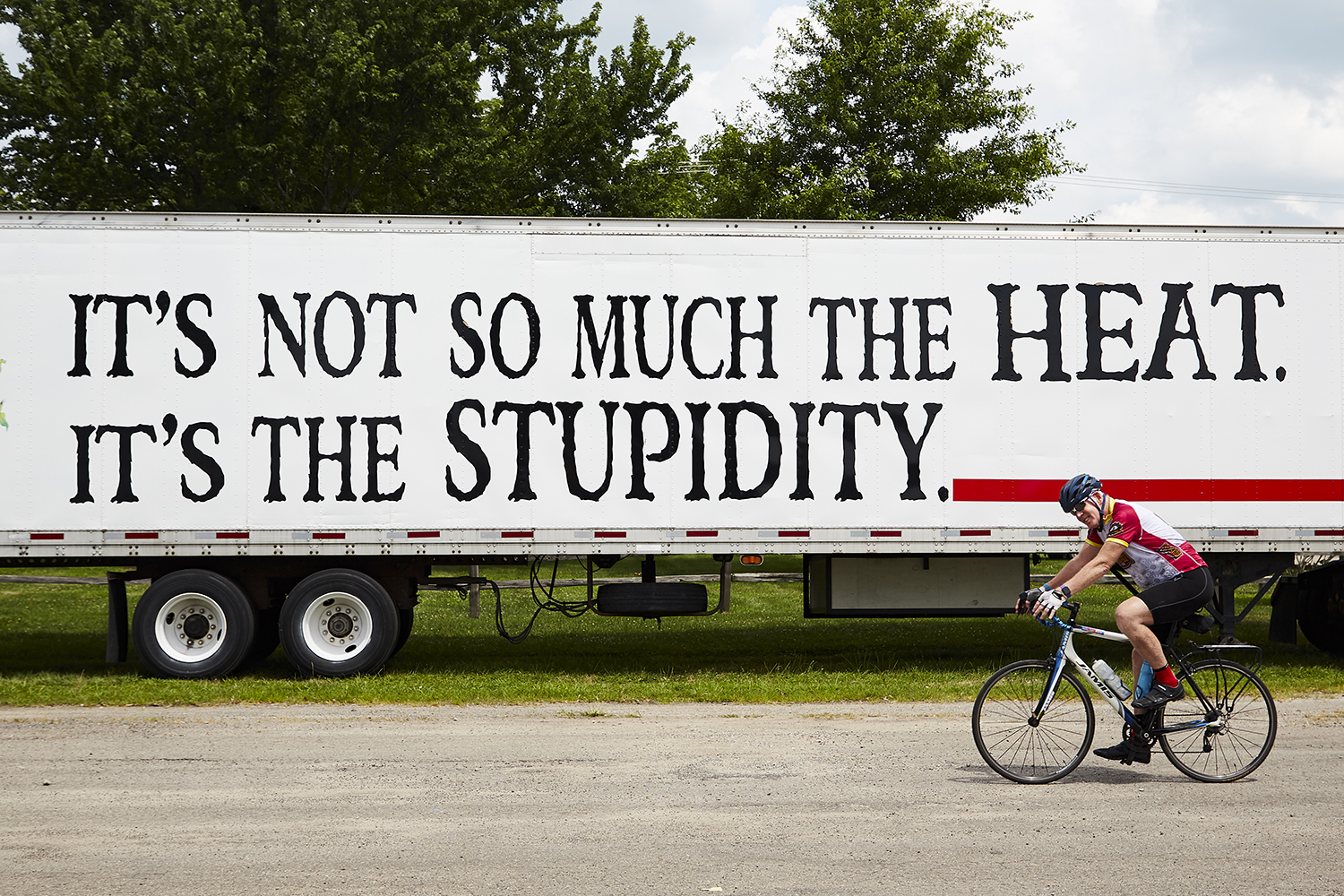  A cyclist rides past a support truck as the Register's Annual Great Bicycle Ride Across Iowa (RAGBRAI) pulls into Fairfield, IA as part of  RAGBRAI XLVII on Thursday, July 25, 2019.  