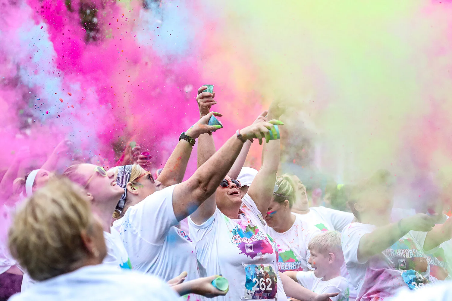 Participants toss colored powder in the air before the Crunch Berry Run in downtown Cedar Rapids on Saturday, Sep. 21, 2019. The Crunch Berry Run is a 5k/1-mile color run designed to raise money for local nonprofits.