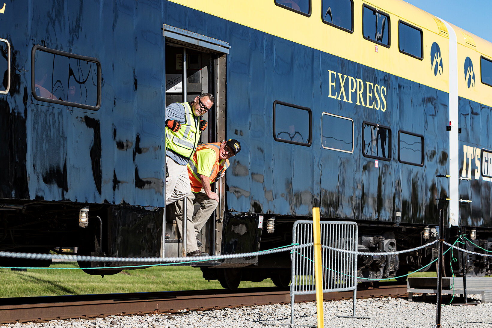  Hawkeye Express personnel hang out of the vestibule of a car to check for train safety as the train pulls out of Coralville, IA en route to Kinnick Stadium on Saturday, Sep. 22, 2018.  