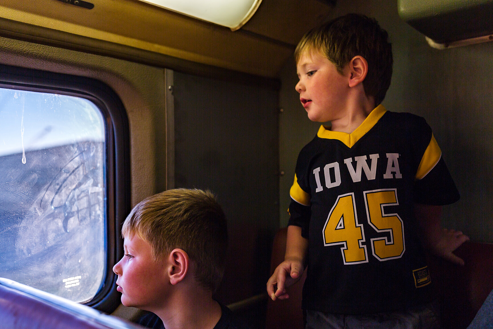  Everett Kinney, age seven, and Ellis Kenny, age 2, look out the window while riding the Hawkeye Express en route to Kinnick Stadium on Saturday, Sept. 22, 2018.  