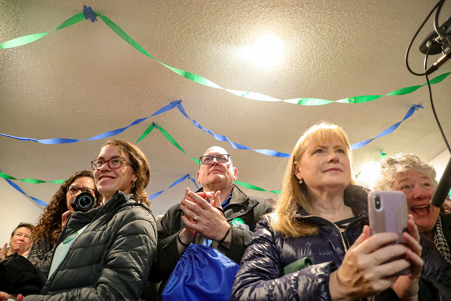  Steven Damm of Iowa City (center) applauds while listening to Democratic Presidential Candidate Amy Klobuchar (D-MN) speak during a visit to Iowa City for the opening of a new campaign office on Saturday, Dec. 28, 2019.  
