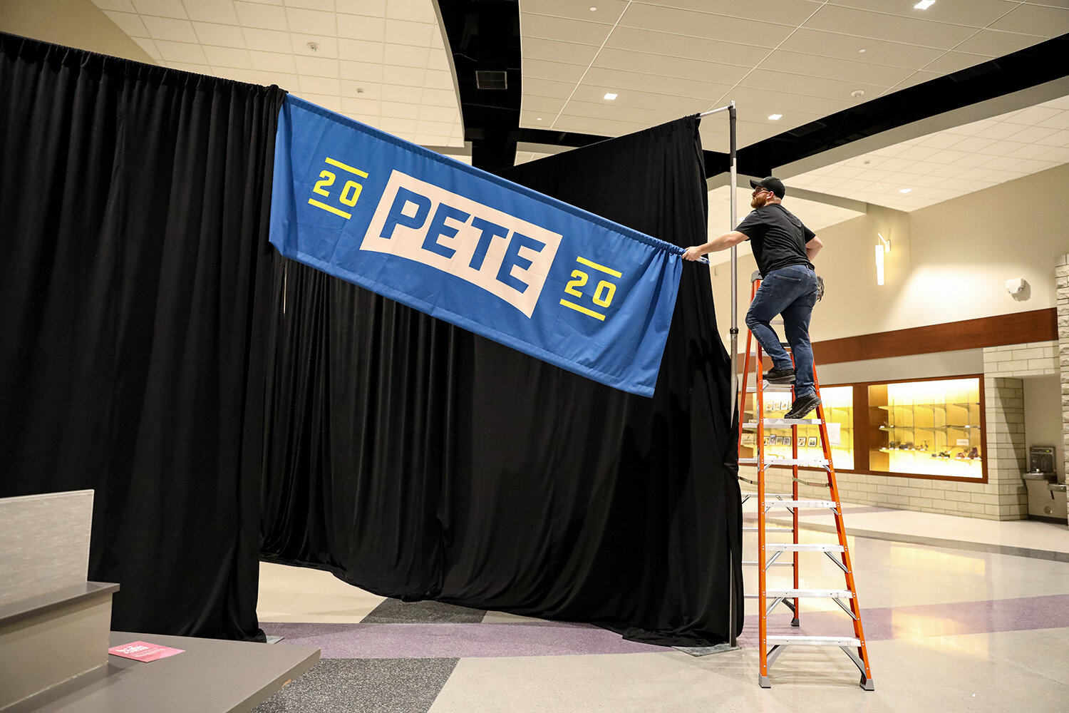 A worker takes down a sign Democratic presidential candidate Pete Buttigieg after a campaign rally at Liberty High School in North Liberty, IA on Monday, Jan. 27, 2020. 