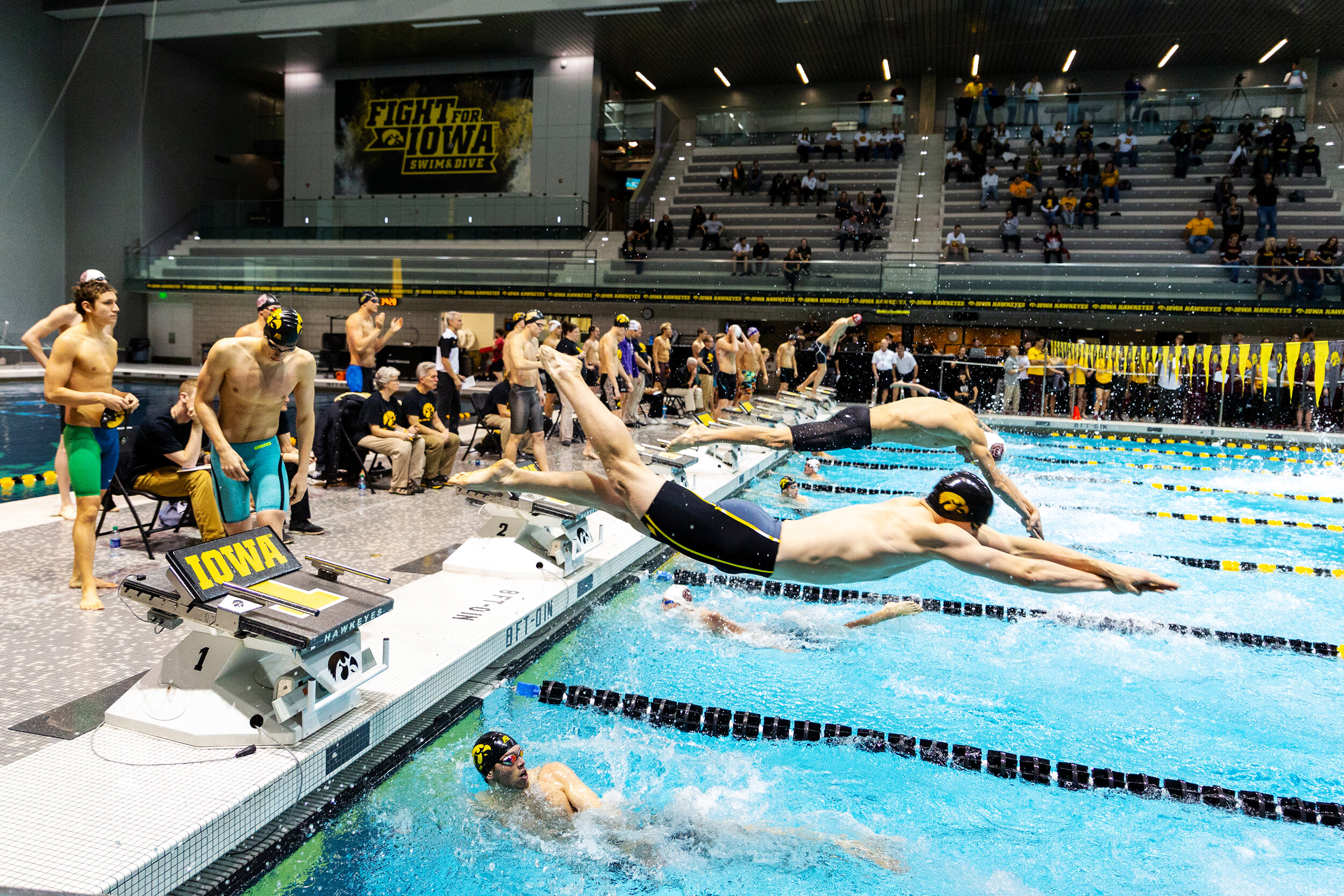  Swimmers leap over teammates during the men's 400m freestyle relay at the Hawkeye Invitational on Saturday, Nov. 17, 2018.  
